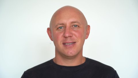 Closeup shoot of middle-aged caucasian bald man looking straight at camera. People and lifestyle concept. Portrait of middle aged man indoors
