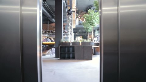 Elevator doors open. Opening the door is an elevator. The door opens and views of the ground floor to the restaurant