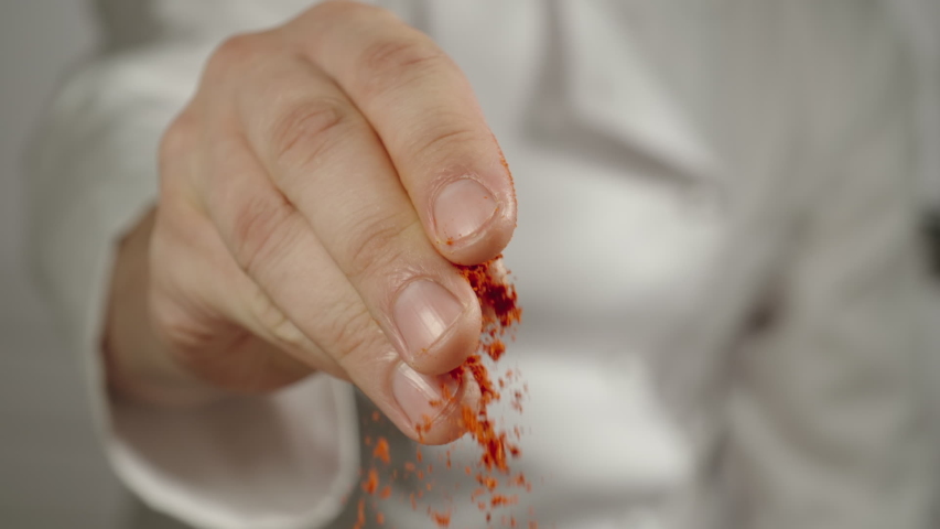 CLOSE UP: Chef Sprinkles Red Pepper Powder While Cooking - Slow Motion