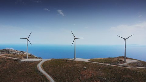 Wind turbines in motion on mountain peak by Mediterranean sea, Crete, Greece