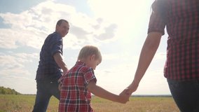 happy family walking nature teamwork friendship care concept slow motion video. father mom and son walk in nature sunset sunlight hold hand. happy lifestyle family parents man and girl hold little boy