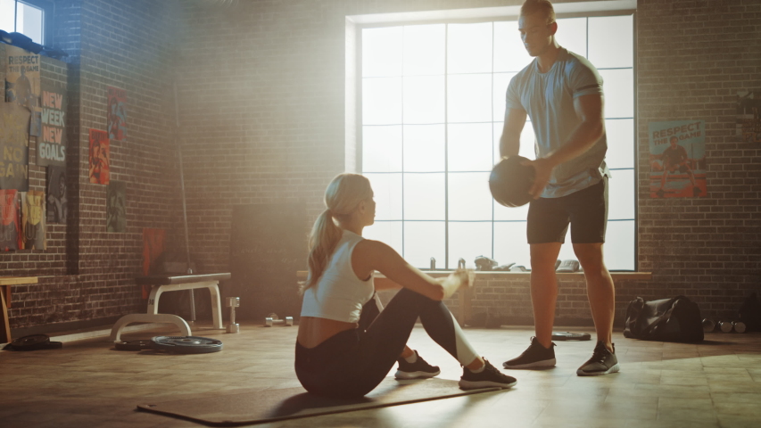 Beautiful Young Girl Exercises with Personal Trainer, Doing Sit-ups with Medicine Ball, Throwing Pass Back and Forth. Fit and Strong Couple Workout. Exercising Strength, Cardio and Power Royalty-Free Stock Footage #1035271484