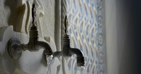Close-up slow motion of water flows of the old taps in the Turkish bath Hammam