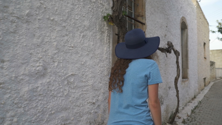 The camera follows a woman walking in the old city of Greece.