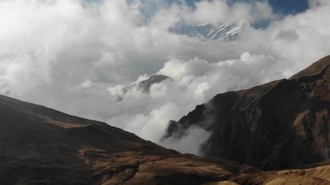 Aerial view towards Dhaulagiri, Tukuche peak and the Kali Gandaki river valley covered with clouds. 4K aerial shooting from the Tholobugin pass.