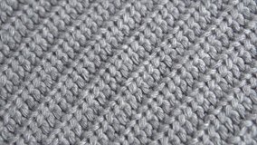 Knitted Wool background. Real Wool clothes texture closeup, dolly shot. Soft grey merino wool macro shot. Woolen fabric. Knitted texture fabric. 4K UHD video