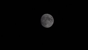 Full moon is moving from left to right time lapse on a cloudless night. 4k Video.
