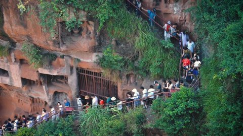 Leshan , Sichuan / China - 05 28 2019: Tourists crowd into a narrow stairwell down to the Leshan Giant Buddha