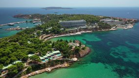 Aerial drone bird's eye video of famous celebrity sandy beach of Astir or Asteras in south Athens riviera with turquoise clear waters, Vouliagmeni, Greece