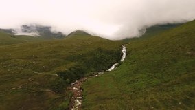 Aerial shot of Isle of Skye waterfall mountains in clouds in 4K