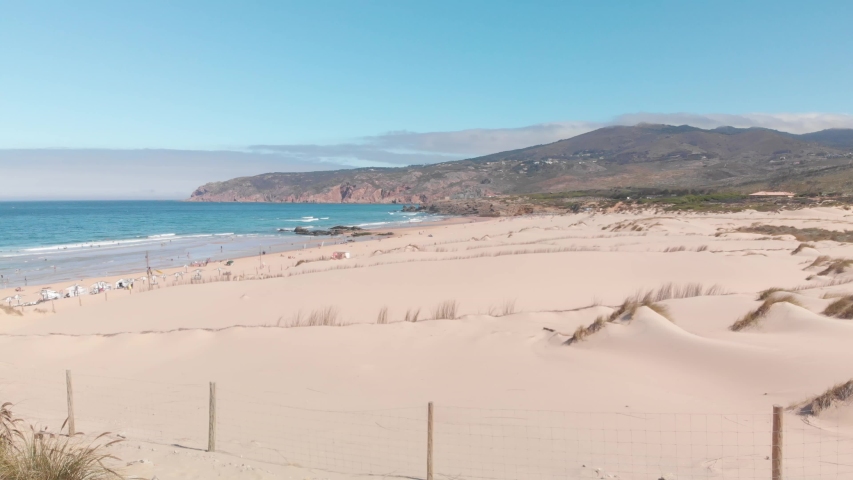 Sand beach like a desert with a cloudy mountain in the background