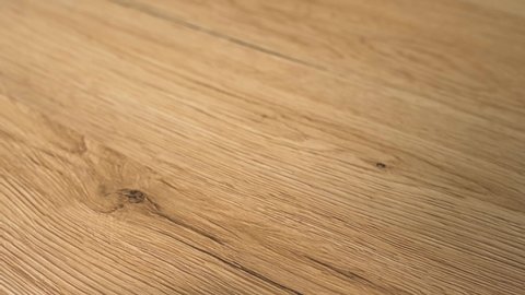 Closeup of the wood floor newly installed. Floor is made of the natural oak hard wood and sanded and finished with natural clear flooring stain. Home improvement and remodel concept in slow motion.