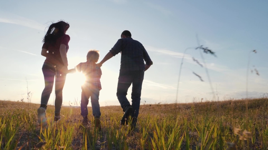 Happy family walks in the park in the sun at sunset. Mom, dad and baby happy walk at sunset. Joint family walks healthy lifestyle. The concept of a happy family and family values Royalty-Free Stock Footage #1035361841