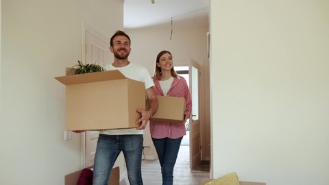 Moving to new apartment of young couple in love smiling friendly coziness home optimistic moment floor box family indoor lifestyle room together amazing funny happiness slow motion