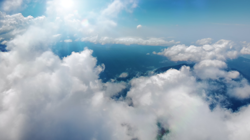 Flying through heavenly beautiful sunny cloudscape. Picturesque timelapse of white fluffy clouds moving softly on the clear blue sky in pure sunshine. Direct view from the cockpit.