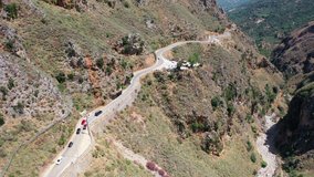 Aerial bird's-eye view video from drone on Topolia Gorge canyon viewpoint site and road. Canyon  runs along the road leading to Elafonissi. Kissamos, Chania prefecture, Crete, Greece.