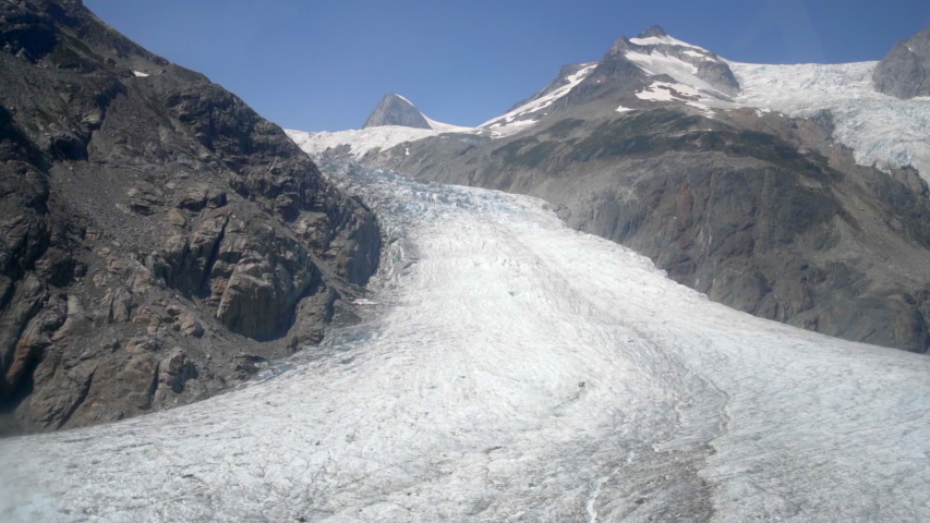 Aerial Right: Snow Covered, Rocky Valley Surrounded By Gray, Snowy Mountains - Mendenhall Glacier, Alaska