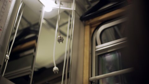 Wide Angle: Cords Hanging From the Ceiling of a Train