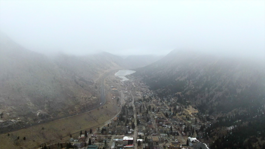 Aerial Forward: Georgetown Nestled in Valley Between Pine Covered Mountains with Steady Traffic Moving Nearby