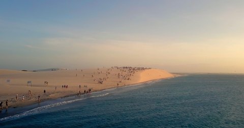 Aerial: People on Amazing Sand Dune by Beautiful Blue Ocean, Jericoacoara, Brazil