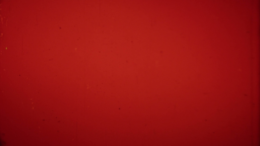 Melting a film frame in a projector on a red 4K background Royalty-Free Stock Footage #1035385787