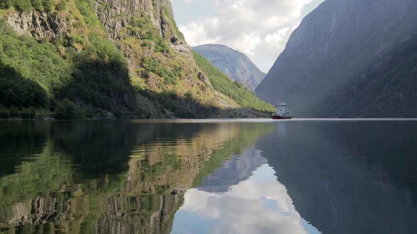 4k Cinematic footage. A big tourist ship sailing in the blue water of the fjord in Gudvangen, Norway.