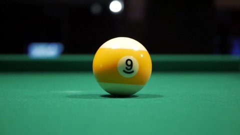 White ball hits nine-ball in a game of pool. Billiards.