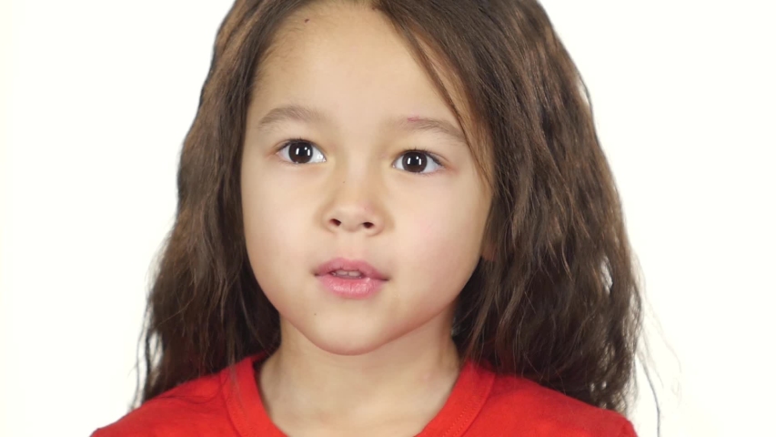 Close-up little girl in red T-shirt posing surprisingly on white background. Happy little girl smiling and laughing on whitescreen for keying or compositing. Slow motion