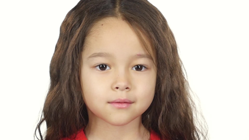 Close-up little girl in red T-shirt posing and thinking about something on white background. Happy little girl thinking about something and she had an idea. Slow motion