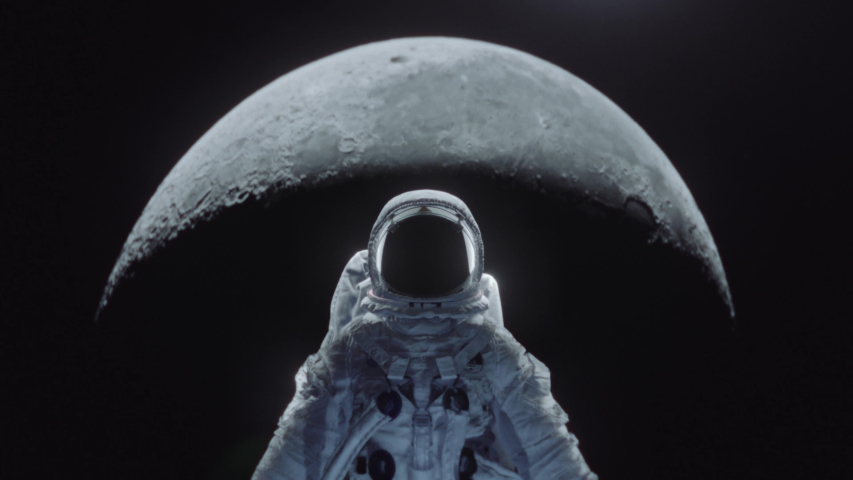 Dolly shot of an astronaut in spacesuit with moon in the background. Royalty-Free Stock Footage #1035404054