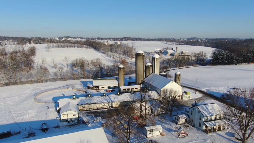 Pennsylvania farm covered in snow, aerial pan around beautiful country scene in early morning 4k