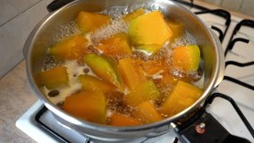 Making of pumpkin dessert, pumpkins are boiling in a pan.