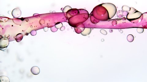 Close up and slow motion of liquid movement under water with merging pink ink.
