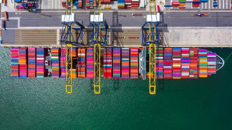 Container ship loading and unloading in deep sea port, Aerial top view business logistic import and export freight  transportation by container cargo ship, Container ship at industrial, Time lapse 4K.