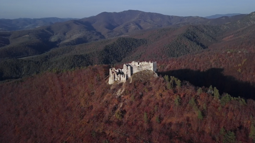 Flight around ruined Uhrovec castle in autumn forest, Slovakia.