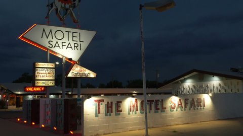 Tucumcari, NM, USA - 06/27/19 - Driving POV past an historic motel along old Route 66 at night