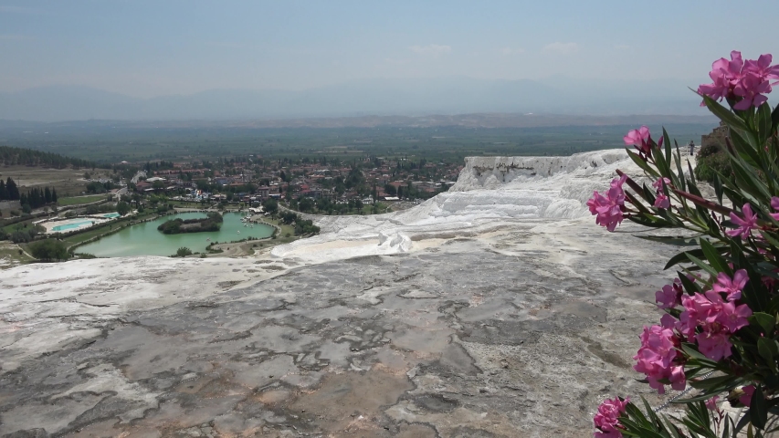 Pamukkale, Denizli, Turkey - 16th of July 2019: 4K View on gray sinter terraces and small lake 
