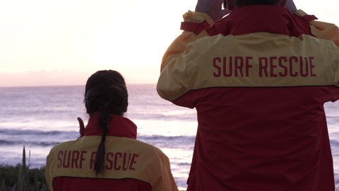 Surf Lifesavers Look Over the Ocean from the Beach