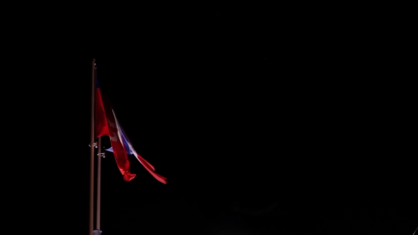 Flags of city of Lyon, along with the national flag of France fluttering together in wind over the bridge over a river in the city of Lyon, France. 