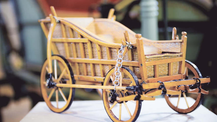 Wooden retro carriage model dolly slide. Showcase of very old traditional carriage in focus.