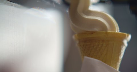 Close-up filling of wafer cup with ice cream. Ice cream in a cone. 4K Slow Motion