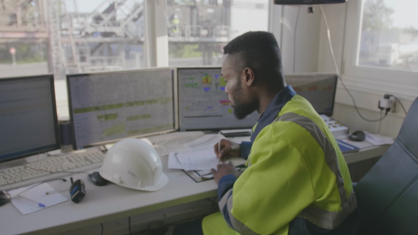 Professional african engineer working on new project sitting in industrial control room Royalty-Free Stock Footage #1035433655