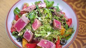 Tuna salad. Serving vegetable salad with tuna in a restaurant. Nisuaz. Food video macro slow motion 
