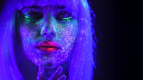 Fashion model woman in neon light, beautiful model girl colorful bright fluorescent make-up, painted skin, Body Art design of disco female in UV, colorful make up. Night club. 4K UHD video footage