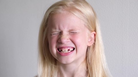 Little cute blonde kid girl is brushing teeth. Fun lifestile play dentist game. Children smile. Health care, dental hygiene