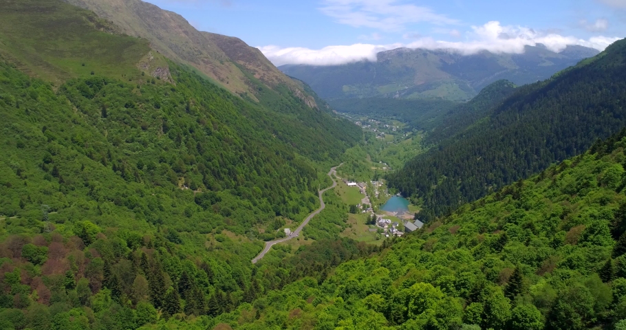 Aerial, drone shot, over forest, towards the Artigues town, in a valley, on a sunny, summer day, at Col du Tourmalet mountain pass, in the Hautes Pyrenees mountains, in France