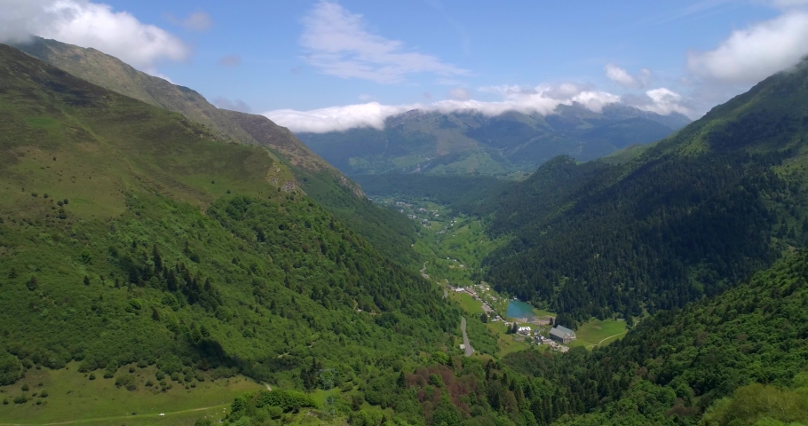 Aerial, tracking, drone shot, overlooking the Artigues village, in a valley, on a sunny, summer day, at Col du Tourmalet mountain pass, in the Hautes Pyrenees mountains, in France