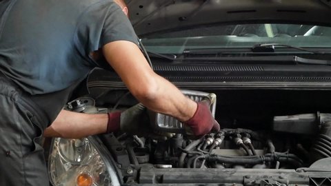 Pouring oil into a car engine, close up. Mechanic pours oil into the engine.