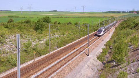 NORMANDY, FRANCE - CIRCA 2018 - A high speed electric passenger train passes through the countryside of Normandy, France.