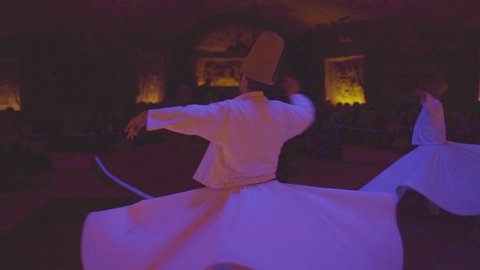 TURKEY - CIRCA 2018 - Whirling dervishes spin in a trance in a darkened mosque in Turkey.